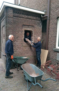 vrijwilligers helpen bij de sloop van een muur